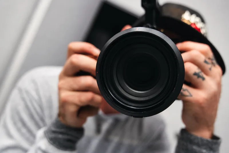 Morgan Ryan holding a camera, photographed behind the lens